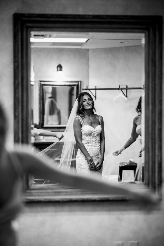 Bride in white dress looking in the mirror